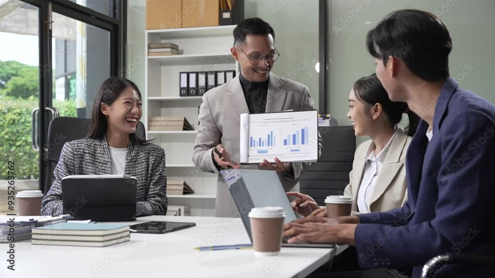 In an office, an Asian team meets at a desk, analyzing financial data on a monitor. They discuss business finance, operational guidelines, and strategies for success, data-driven decision-making. In an office, an Asian team meets at a desk, analyzing financial data on a monitor. They discuss business finance, operational guidelines, and strategies for success, data-driven decision-making.