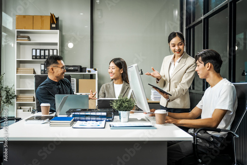 Asian colleagues meet at a desk, discussing business financial terms, investment strategies, managing funds. Their focus is on planning, analysis, and operations to ensure stability and success.