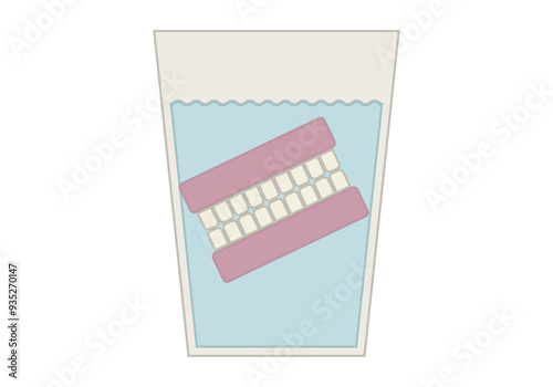 Dentadura postiza en un vaso de agua