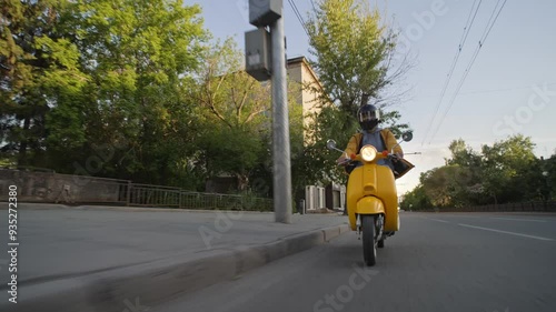 Courier man carry package moped. Guy ride yellow retro scooter city street deliver box in backpack. Fast food delivery service. Person drive bike with store bag. Express home order. Rush rider hurry.