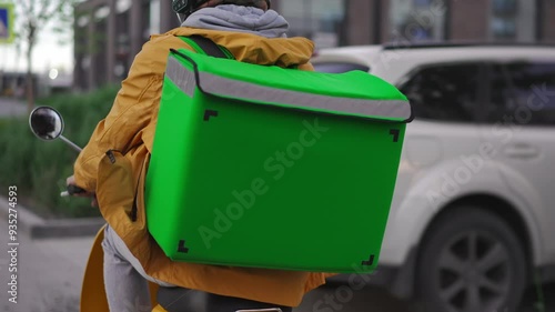 Courier man carry package moped. Guy ride scooter city street deliver box. Green backpack mock up. Fast food delivery service. Person drive bike thermal store bag. Express home order. Rush rider hurry photo