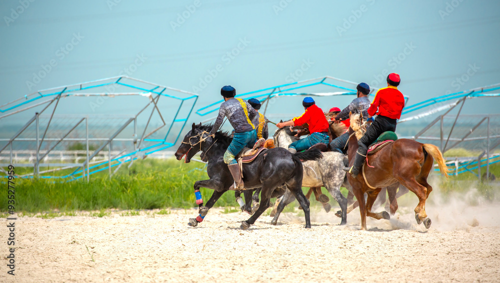 Celebrating the Kazakh New Year Nauryz. People in national clothes have fun on horses. Ethnic entertainment. Celebrating the Kazakh New Year Nauryz. People in national clothes have fun on horses. Ethnic entertainment.