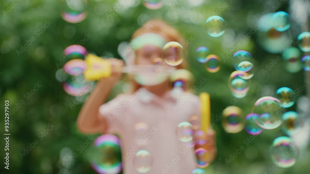 Girl blowing bubbles outdoors in sunlight