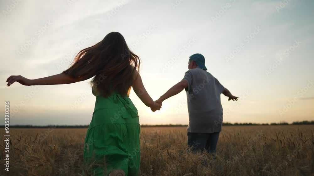 Couple walking hand in hand. Silhouette of couple in wheat field at ...