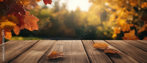 A serene autumn scene featuring colorful leaves on a wooden table with a soft bokeh background illuminated by natural sunlight.