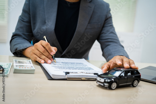 close-up of a customer signing a car insurance contract at an agency. The salesman hands over the keys, finalizing the agreement. importance of financial protection and assurance.