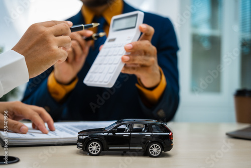 close-up of a car salesman handing the keys to an Asian customer after signing an insurance agreement. business transaction, ownership and customer service in the automotive industry.