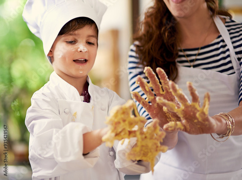 Child, mother and dirty hands for baking with cookie dough, fun recipe and learning in home. Mom, kid and messy in kitchen for development, process and ingredients for culinary skills with support photo