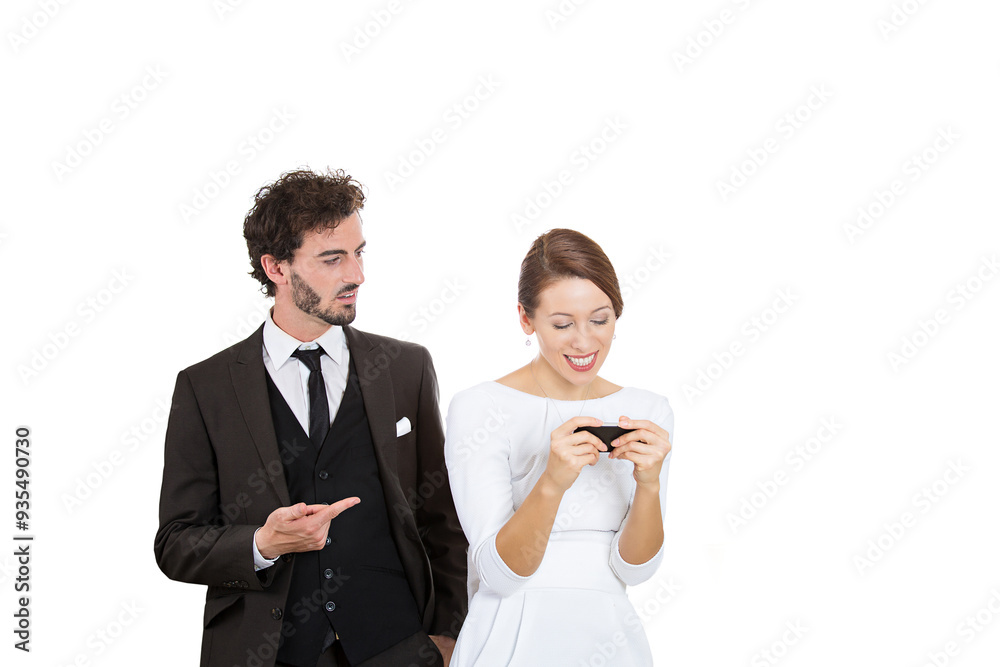 Portrait of a frustrated man pointing finger at his wife who is constantly texting on her cellphone Portrait of a frustrated man pointing finger at his wife who is constantly texting on her cellphone