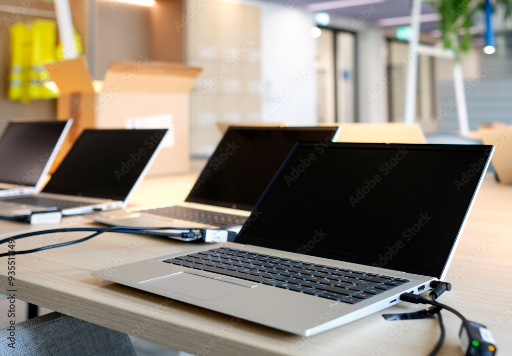 Laptops on a table in a co-working space Laptops on a table in a co-working space