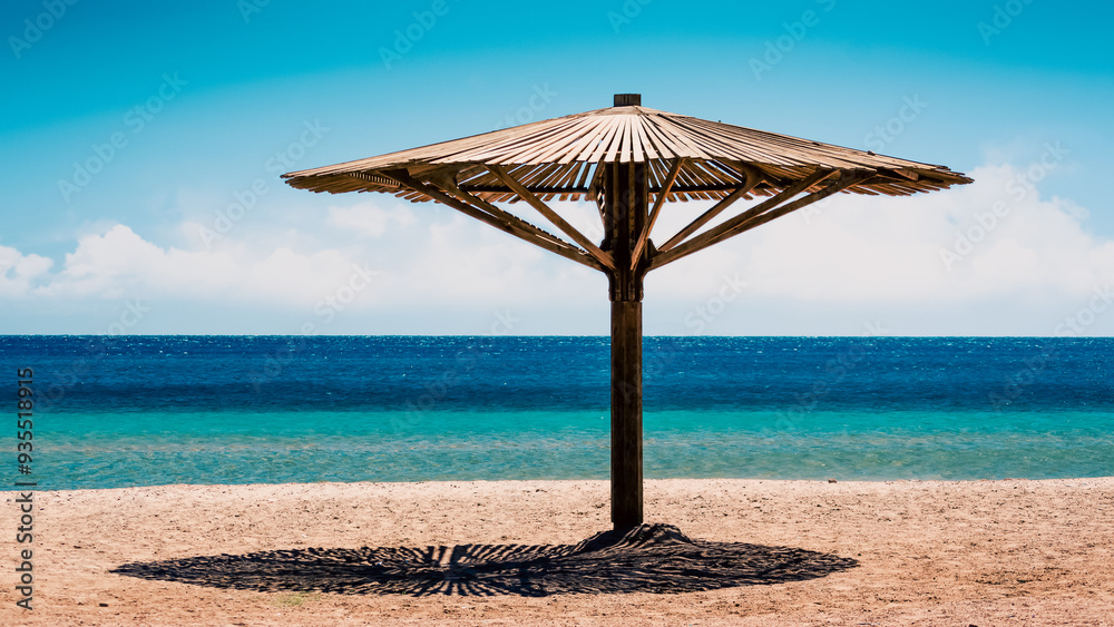 wooden beach umbrella on the shore without people of the Red Sea in Egypt wooden beach umbrella on the shore without people of the Red Sea in Egypt