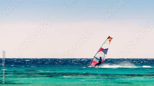 surfer rides in the Red Sea on the background of a clear sky in Egypt. Dahab