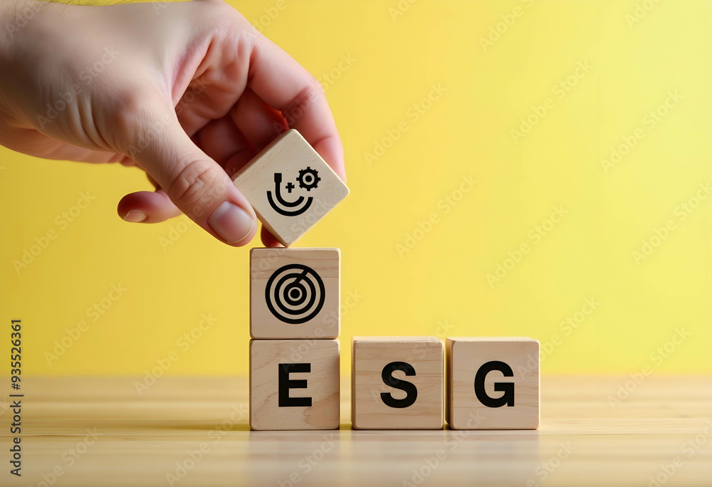 Hand-put wooden cubes on ESG text on a yellow background Hand-put wooden cubes on ESG text on a yellow background