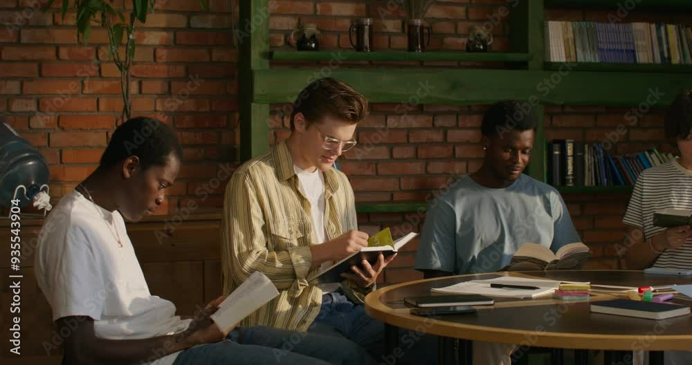 A group of young people of different nationalities join hands and begin prayer while sitting at a table indoors. Daylight A group of young people of different nationalities join hands and begin prayer while sitting at a table indoors. Daylight