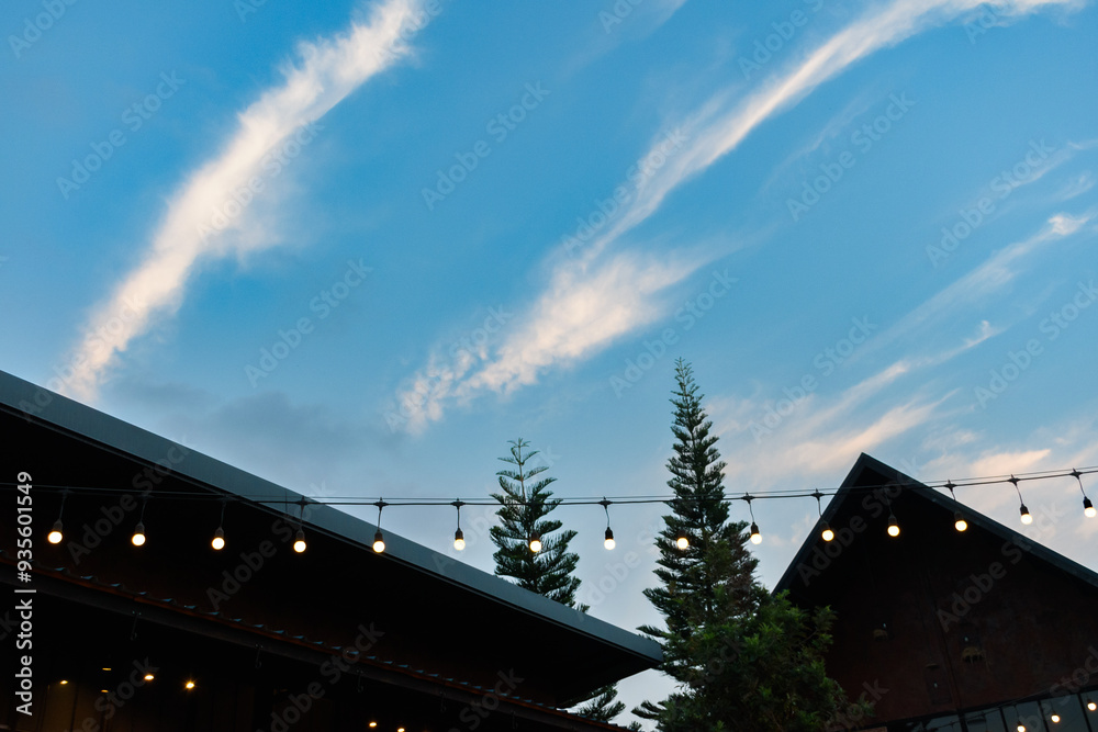 Roof of modern farmhouse style with tree against blue sky sunset background, Interior of modern cafe, Lighting in warm color, Sunset sky and modern house eaves. Roof of modern farmhouse style with tree against blue sky sunset background, Interior of modern cafe, Lighting in warm color, Sunset sky and modern house eaves.
