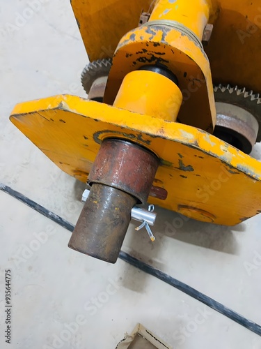 Close-up of a yellow industrial gear mechanism showing wear and use, highlighting rugged durability in heavy-duty applications. Perfect for showcasing industrial equipment and mechanical components.