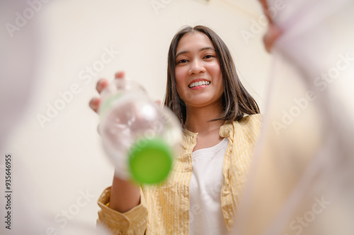 POV from trash bin of used plastic water bottle dumping in to trash bin by housekeeper. Garbage recycle, plastic reuse house waste sorting for sustainable life concept.