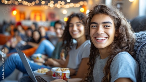 A group of college students gathered in a dorm room, watching a movie on a laptop and sharing snacks, creating a fun and relaxed atmosphere Stock Photo with copy space