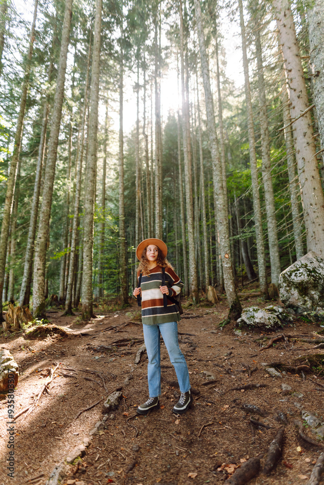 Cheerful woman exploring a lush green forest wearing a stylish sweater and hat on a sunny day Cheerful woman exploring a lush green forest wearing a stylish sweater and hat on a sunny day