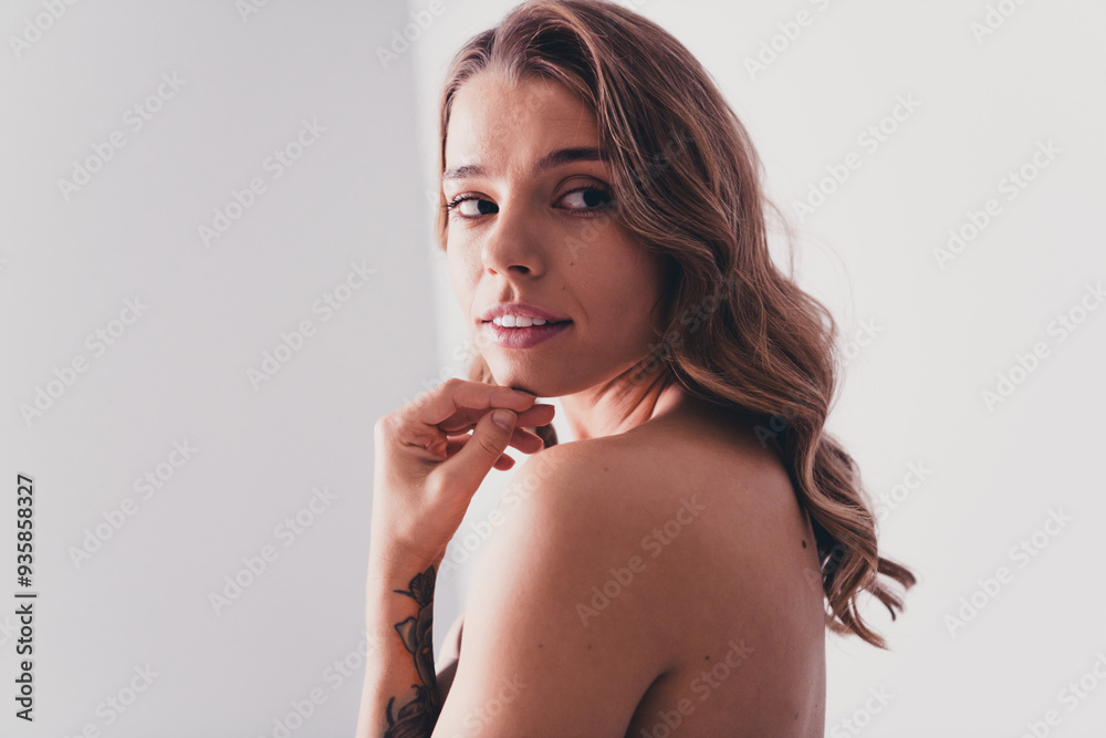 Photo of lovely young lady touch face look empty space turn around no retouch bare shoulders isolated on gray color background Photo of lovely young lady touch face look empty space turn around no retouch bare shoulders isolated on gray color background
