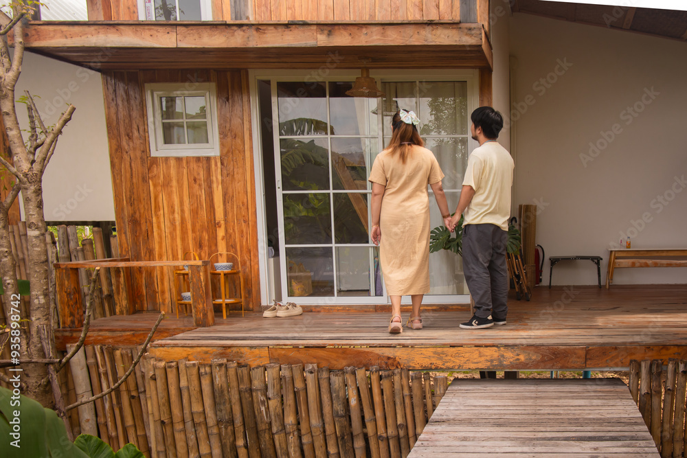 a family sits on a porch with a wooden house in the background