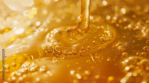 A golden stream of liquid flowing with bright bubbles, creating a mesmerizing effect of warmth and preciousness, akin to honey or molten gold. photo
