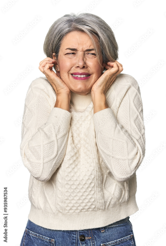 Caucasian mid-age female on studio background covering ears with hands. Caucasian mid-age female on studio background covering ears with hands.