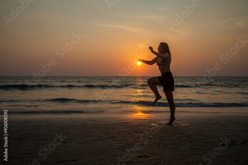 A beautiful girl in a swimsuit jumps at sunset. Sunny colorful sunset. Seashore on the beach. 