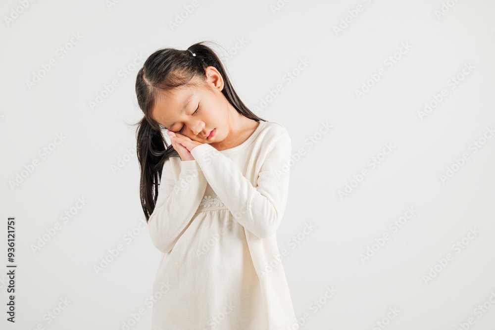 Portrait Asian young kid girl pretends emotions sleeping tired eyes closed dreaming with hands together near face, studio shot on white background, copy space, insomnia concept, kindergarten child Portrait Asian young kid girl pretends emotions sleeping tired eyes closed dreaming with hands together near face, studio shot on white background, copy space, insomnia concept, kindergarten child