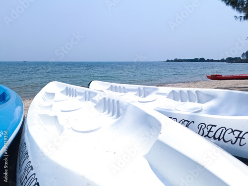 Jepara, Indonesia - August 23, 2024 : View of Blebak Beach in Jepara in the morning and the parked canoes photo