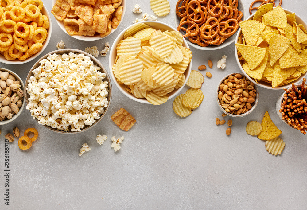 Set of many bowl with different salty snacks. Chips, popcorn, nuts, nachos and pretzels Set of many bowl with different salty snacks. Chips, popcorn, nuts, nachos and pretzels