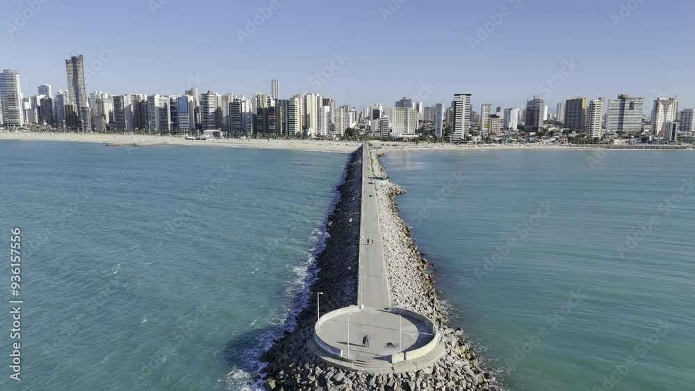 Drone flies up and away from Joao Cordeiro Pier at Praia de Iracema beach in Fortaleza, Ceara, Brazil