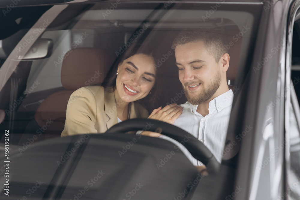 Portrait of smiling beautiful couple sitting in modern luxury car, happy excited young man and woman buying new car in dealership. Portrait of smiling beautiful couple sitting in modern luxury car, happy excited young man and woman buying new car in dealership.