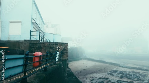 People walking along the quite streets of Staithes a sleepy fishing village on the Yorkshire coast of England. With cobbled streets and old stone built houses. Harbor walls and friendly public houses.