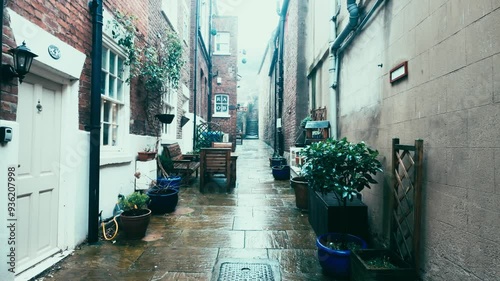 People walking along the quite streets of Whitby a sleepy fishing village on the Yorkshire coast of England. With cobbled streets and old stone built houses. Harbor walls and friendly public houses.