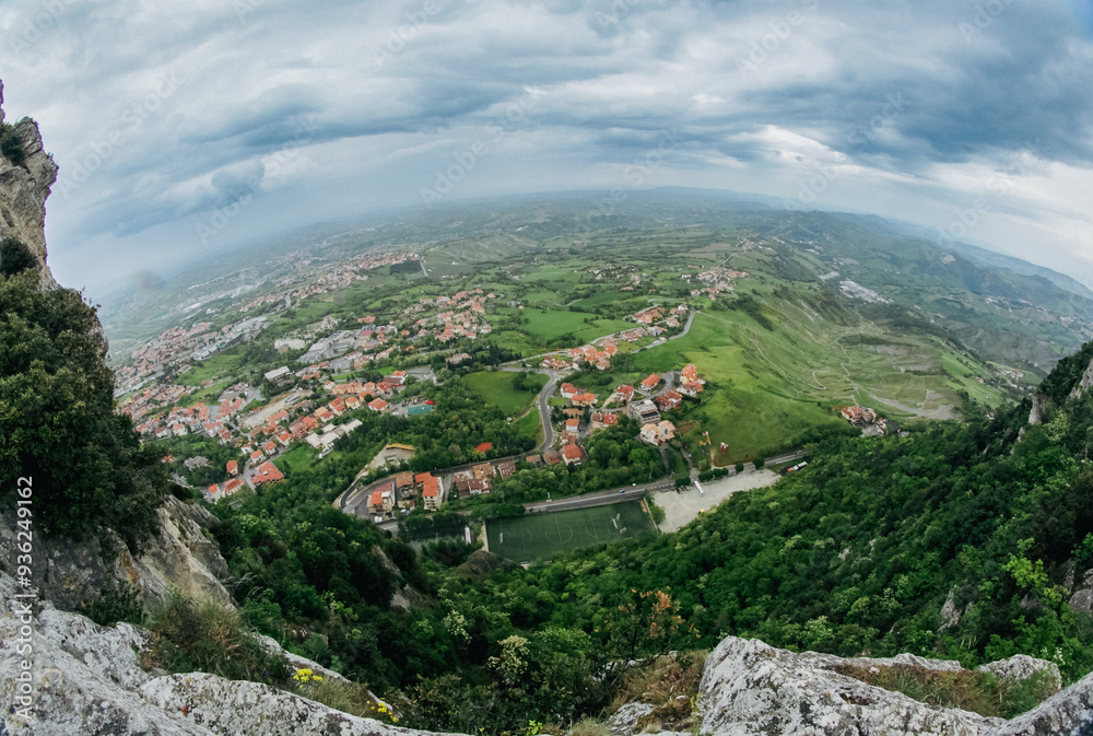 Fototapeta premium Aerial view of San Marino’s lush landscape and historical architecture on a cloudy day