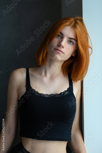 Cute red-haired girl, studio portrait on a black background.