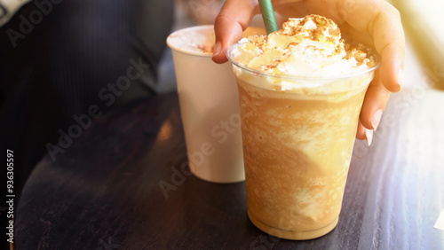 Fototapeta Naklejka Na Ścianę i Meble -  Detail of hand taking a pumpking spice latte, the perfect autumn beverage