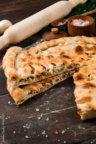Obraz na płótnie Fresh closed pie with chicken, onions, tomatoes, herbs and spices. w salonie