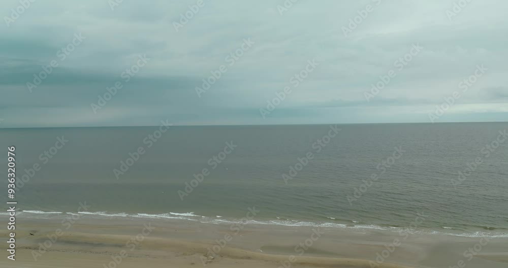 A Serene Scene of Waves Gently Rolling Onto the Shore Beneath a Somber, Overcast Sky in Hirtshals, Denmark, Europe - Drone Flying Forward A Serene Scene of Waves Gently Rolling Onto the Shore Beneath a Somber, Overcast Sky in Hirtshals, Denmark, Europe - Drone Flying Forward