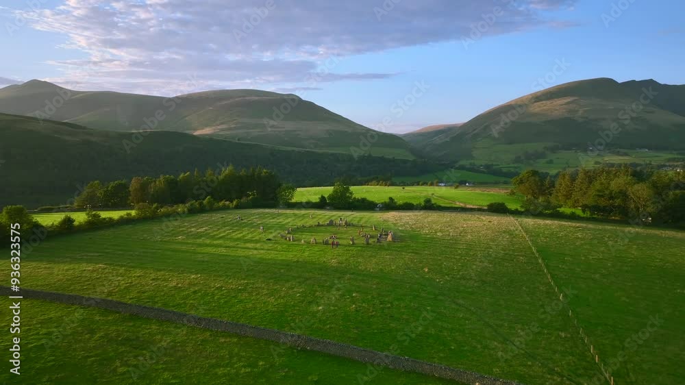 People visiting ancient stone circle at golden hour with mountain background. Castlerigg, Lake District National Park, Cumbria, UK People visiting ancient stone circle at golden hour with mountain background. Castlerigg, Lake District National Park, Cumbria, UK