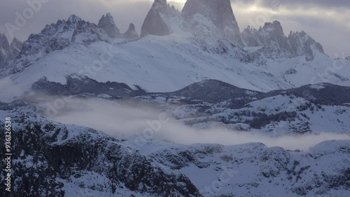 Winter landscape view of Mount Fitz Roy massif with snow covered forests in southern Patagonia. Vertical granite walls before sunset. Los Glaciares National Park, Argentina. photo