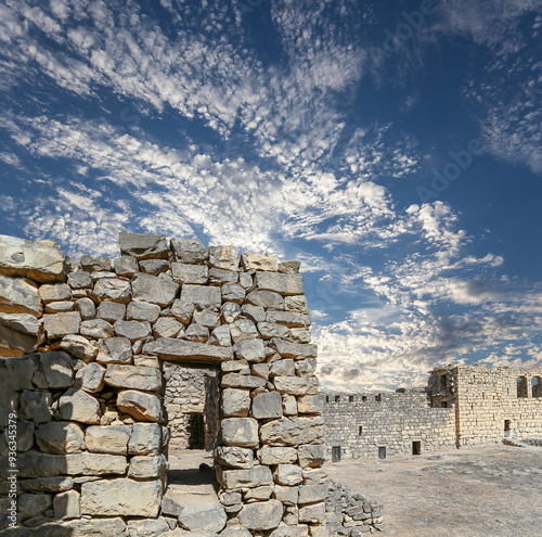 Ruins of Azraq Castle (Qasr al-Azraq) is a crusader castle (300AD),  central-eastern Jordan, 100 km east of Amman, Jordan. Against the background of a beautiful sky with clouds photo