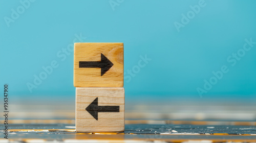 Wooden blocks with arrow icons rotating, representing adaptability and the need for strategic shifts in decision-making and planning processes.