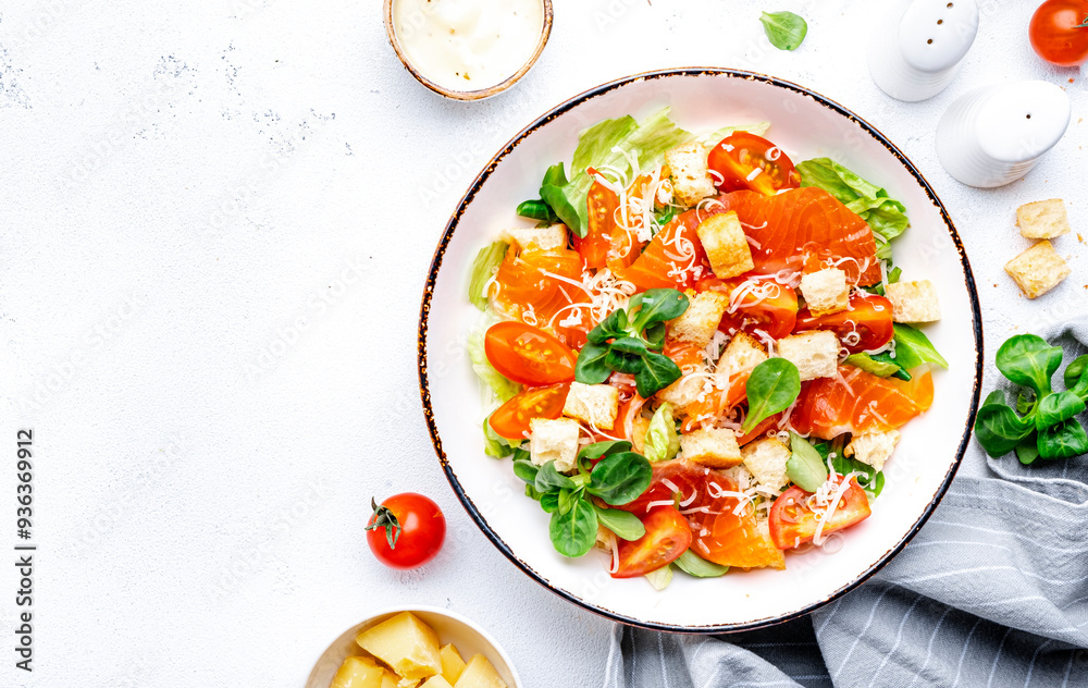 Delicious salad with salmon, iceberg lettuce, croutons, grated parmesan cheese and caesar dressing. White background, top view Delicious salad with salmon, iceberg lettuce, croutons, grated parmesan cheese and caesar dressing. White background, top view