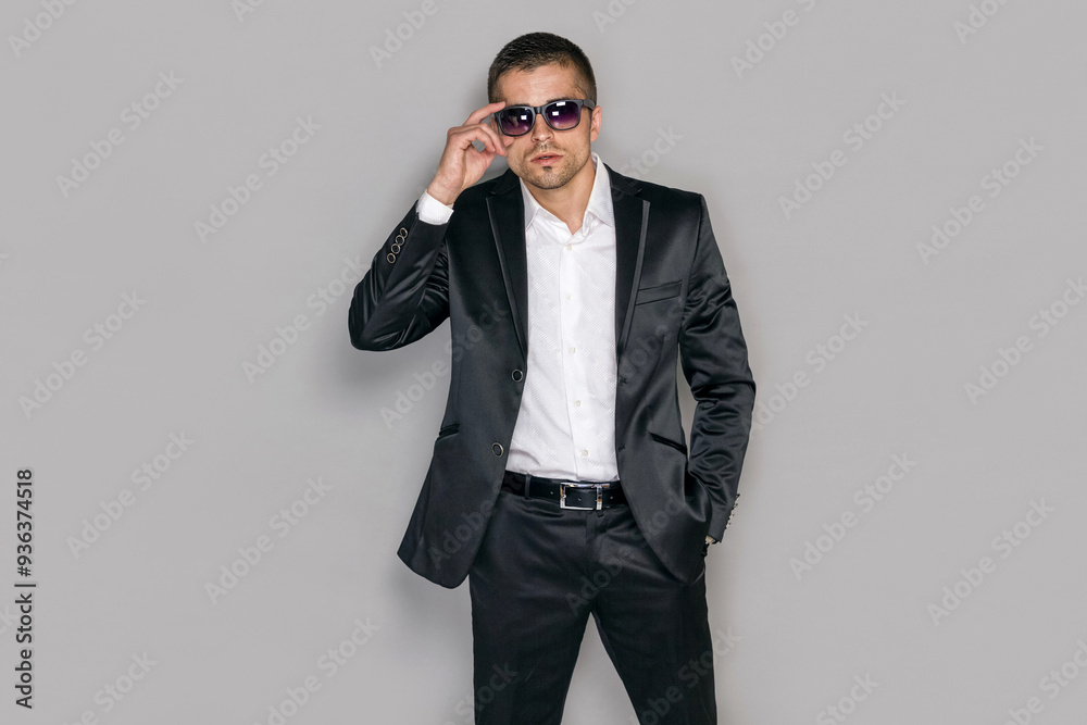 Handsome serious secret service agent in sunglasses over gray background, isolated. Handsome serious secret service agent in sunglasses over gray background, isolated.