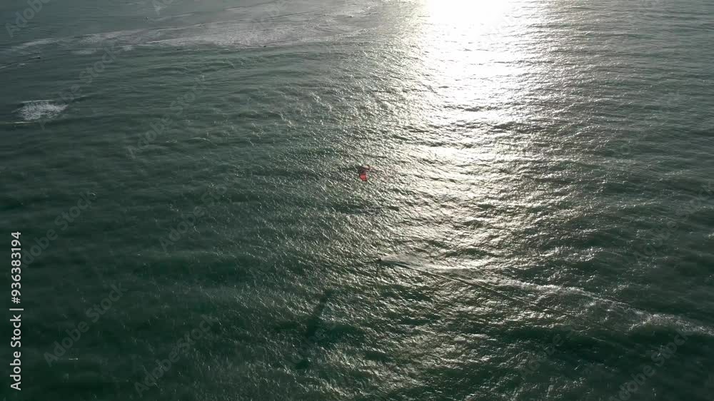 Pessoa velejando de Kitesurf no sunset no mar