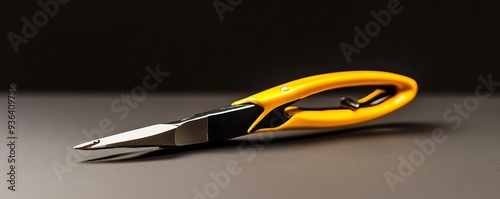 A close-up image of a sleek yellow-handled scissors on a dark background, highlighting its sharp blades and ergonomic design. photo