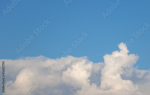 Fototapeta Naklejka Na Ścianę i Meble -  White clouds in the blue sky, close-up of a white cloud on the right side