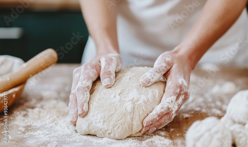 hands of a baker kneading bread dough with flour and water